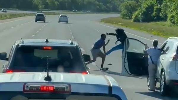 男人们躲避汽车，在高速公路上的战斗中丢了鞋子